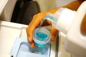 液体洗剤を洗濯機に入れている