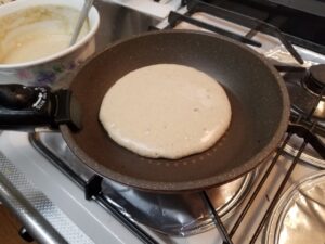 フライパンで焼き始めたホットケーキ